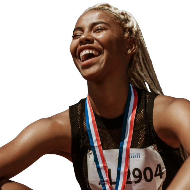Smiling athlete with blond hair sitting, wearing a medal and competition bib numbered 2904.